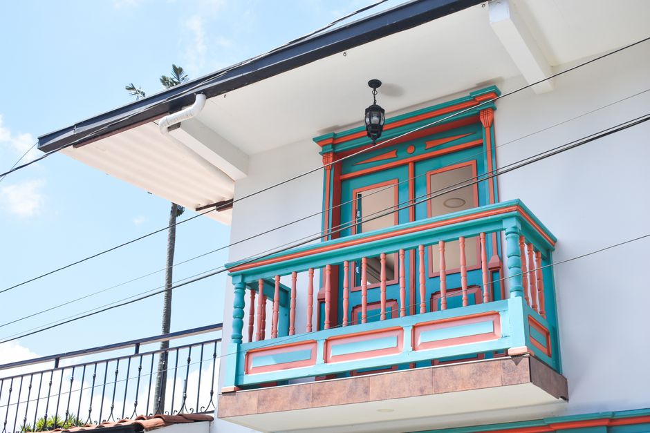 Vibrant traditional balcony with wooden elements and geometric patterns against a clear sky.