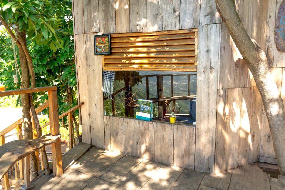 Charming rustic wooden house exterior with a large window and patio area.