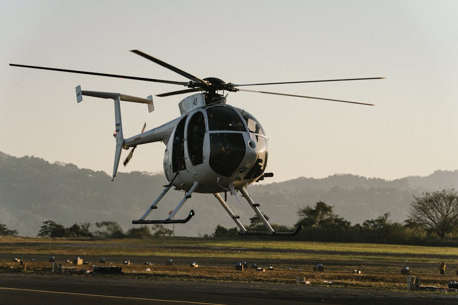 A helicopter prepares to take off at sunset in El Salvador, showcasing the stunning landscape.