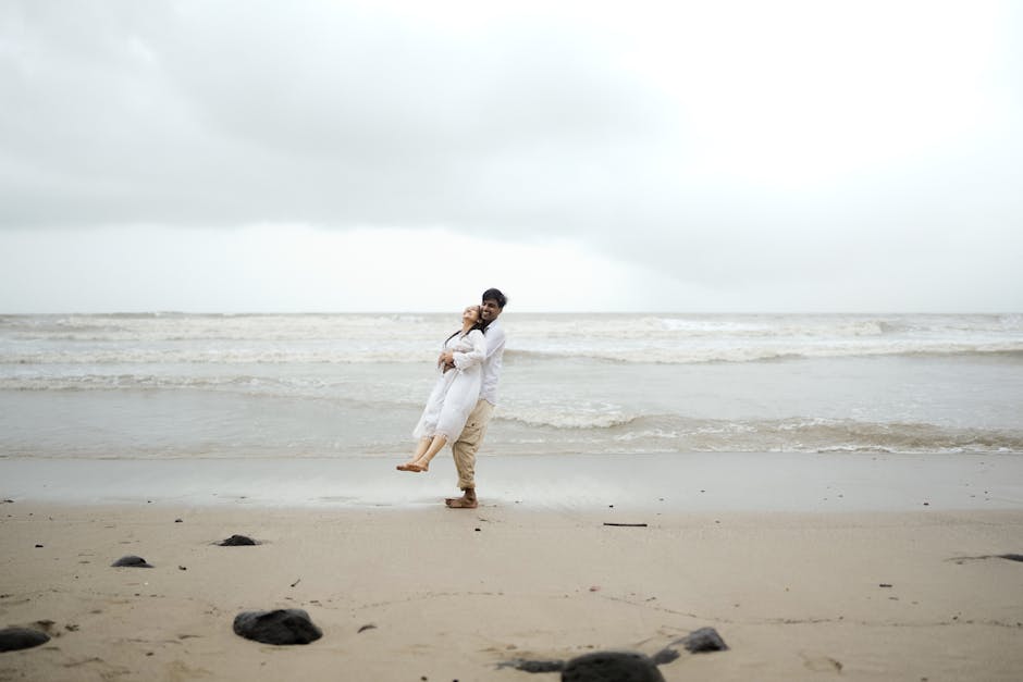 A couple lovingly embraces on the sandy shores of Alibag beach, Maharashtra, India.