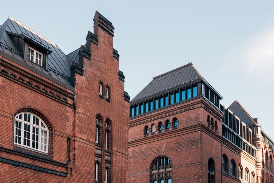 Low angle view of historic red brick buildings in Hamburg, showcasing urban architectural style.