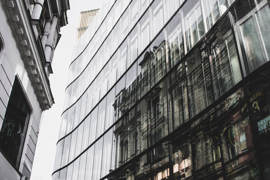 Reflective modern building design in Prague's urban landscape, merging contemporary and historic architecture.