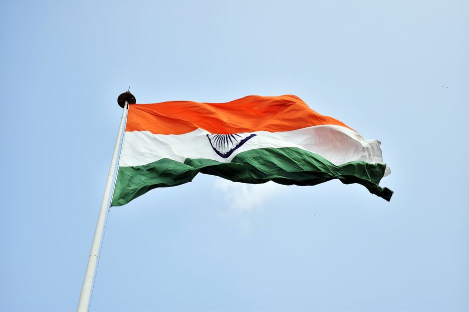 The Indian national flag waves proudly against a clear blue sky in New Delhi.