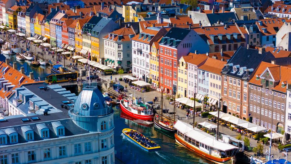 Vibrant Nyhavn canal with colorful buildings and boats in Copenhagen, Denmark.