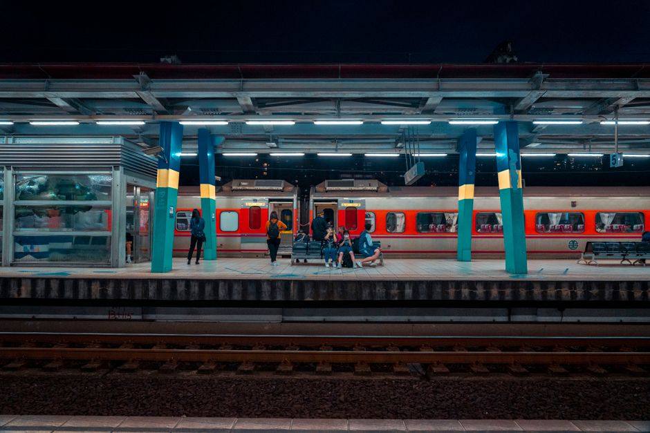 A vibrant nighttime scene of commuters on a train platform, highlighting public transportation.