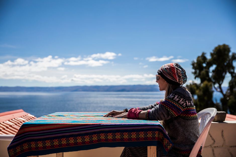 Woman sitting by Lake Titicaca, enjoying a sunny day in La Paz, Bolivia.