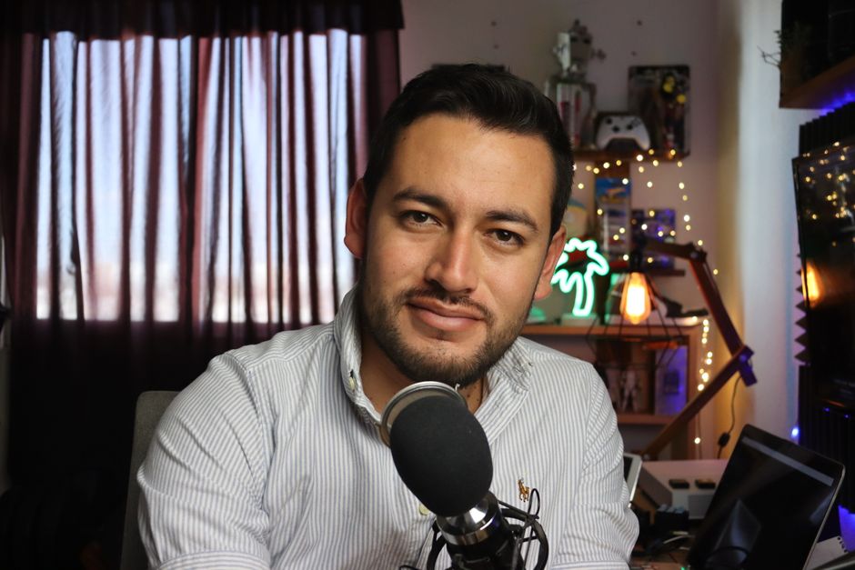 Casual home podcast recording setup with a man using a microphone in a cozy, decorated space.
