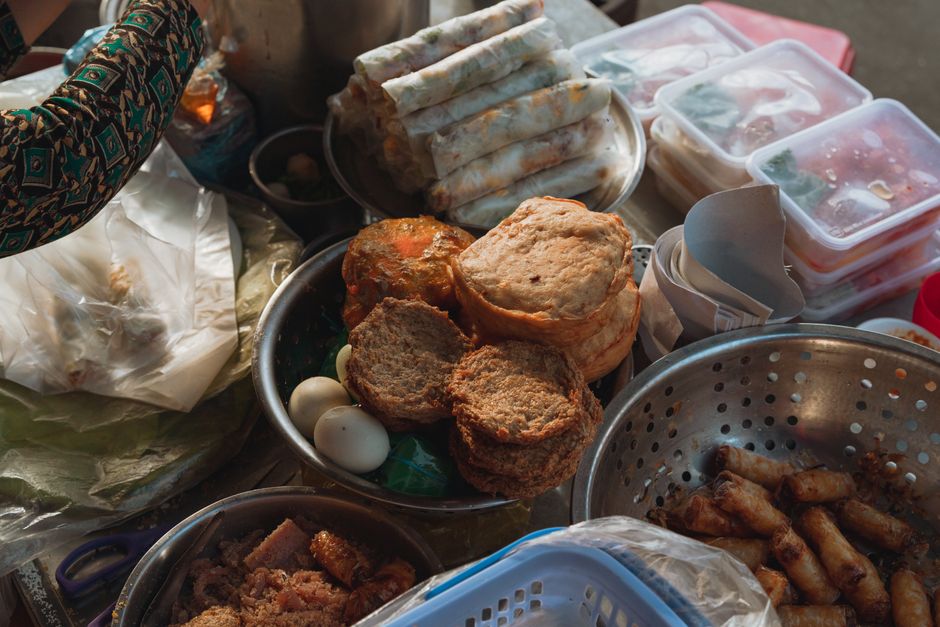 A vibrant assortment of Vietnamese street food at a market in Bình Thuận, showcasing traditional snacks.