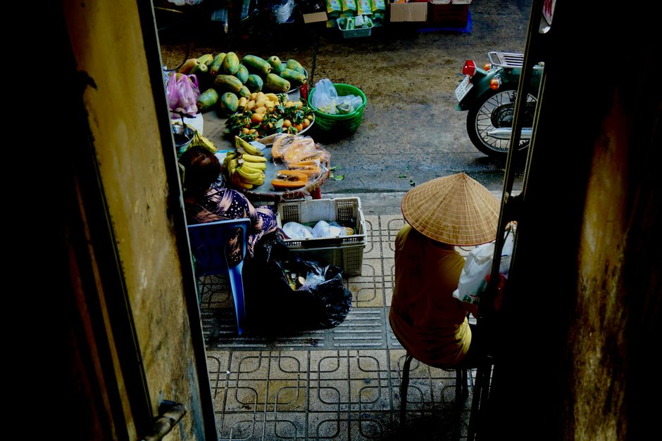 A vibrant view of a traditional outdoor market with fresh produce and two vendors.